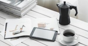 Pracovní stůl s kávou , čtečkou a časopisem